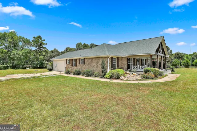 a view of a house with swimming pool and a yard