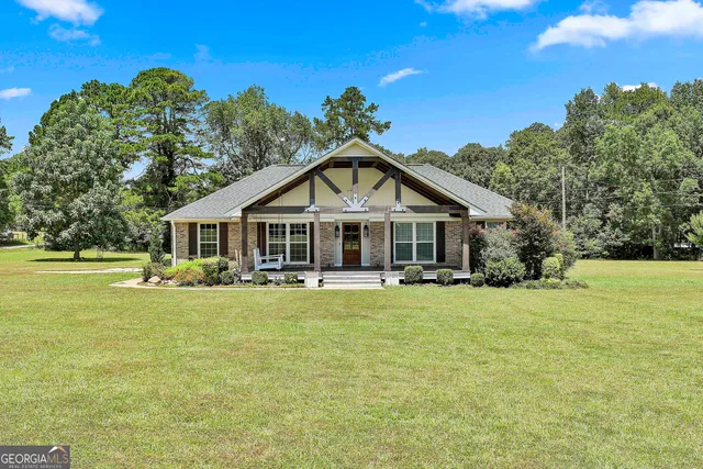 a front view of a house with yard and green space