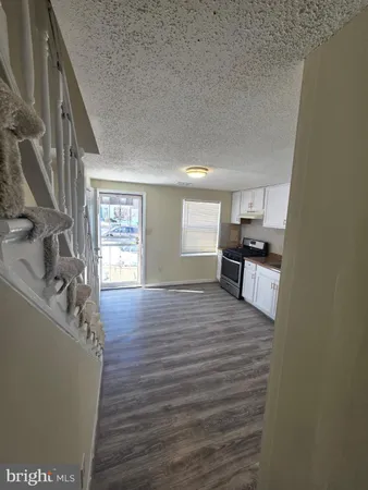 a view of kitchen and hall with wooden floor