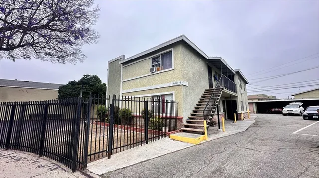 a view of a house with wooden fence and a car parked in front of it