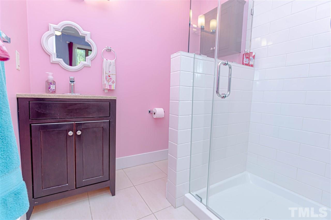 2521 Scouting Trail Raleigh, NC 27615 - Photo 19 of 29 a bathroom with a sink a mirror and shower