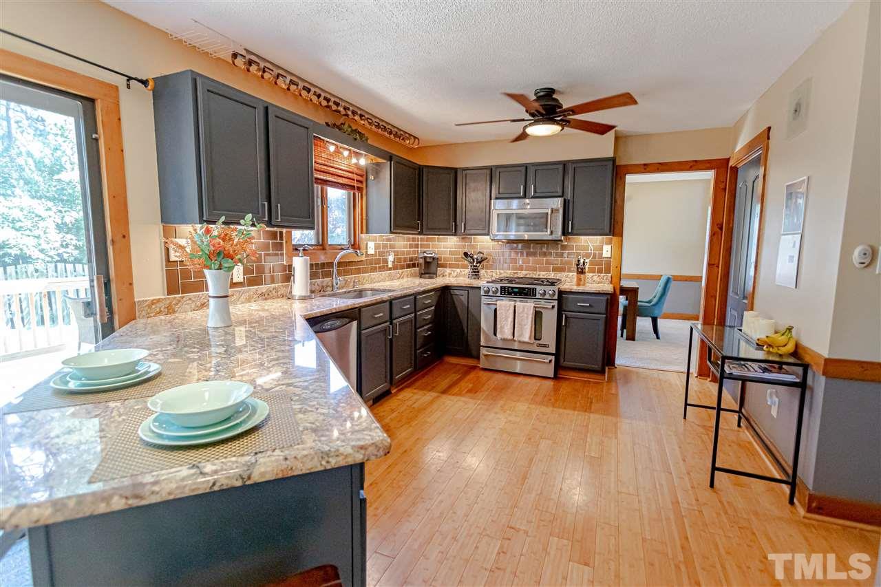 2521 Scouting Trail Raleigh, NC 27615 - Photo 9 of 29 a kitchen with a table chairs stove and wooden floor