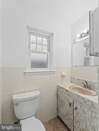 a bathroom with a granite countertop toilet sink and mirror