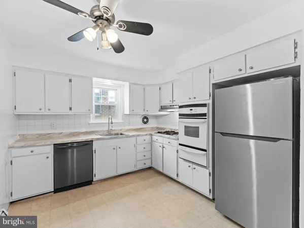 a kitchen with white cabinets and white appliances