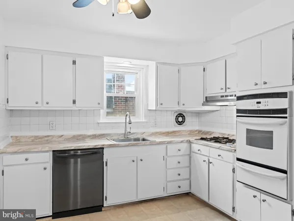 a kitchen with cabinets appliances a sink and a counter