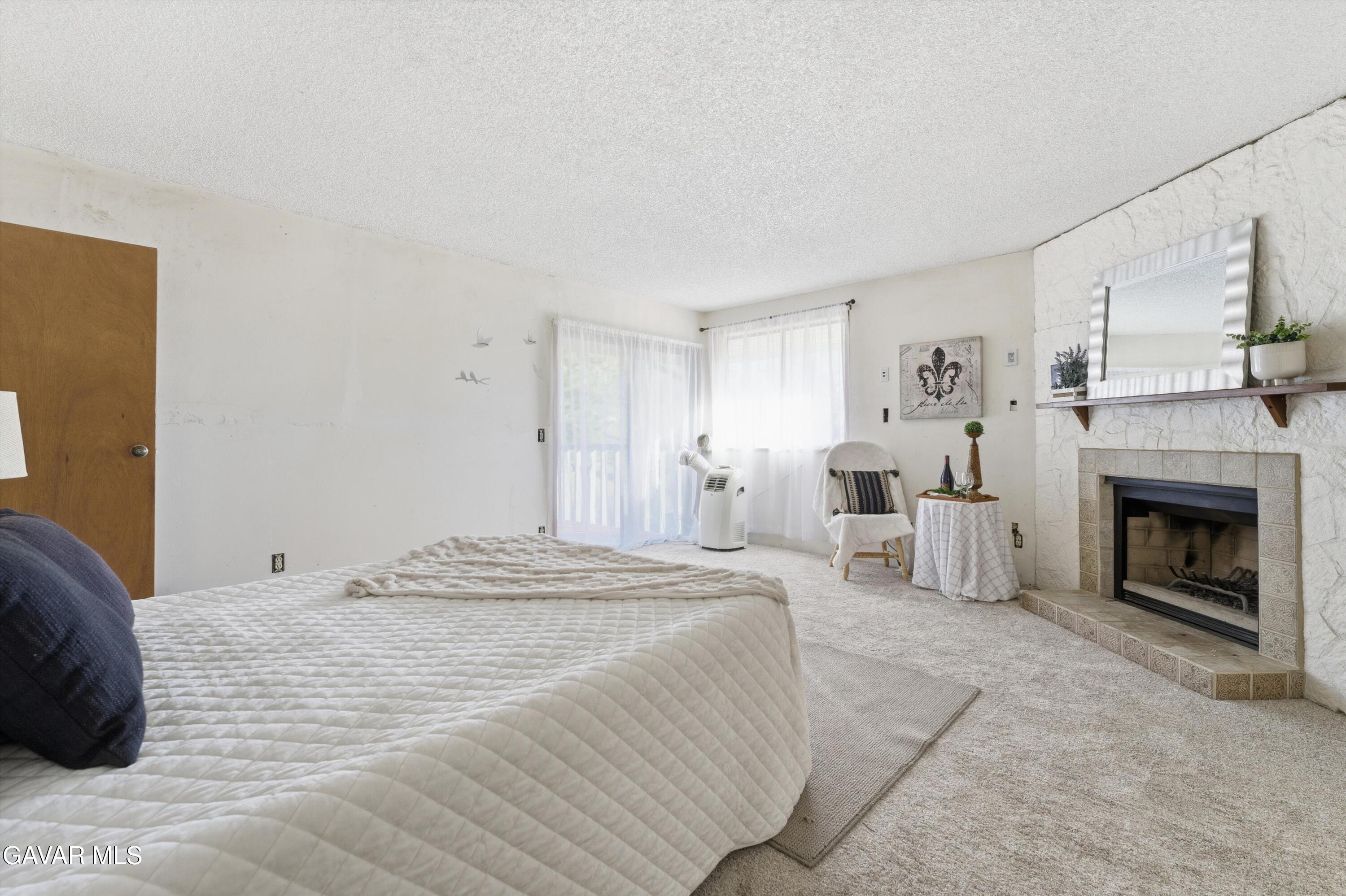 26181 Bear Valley Road Tehachapi, CA 93561 - Photo 19 of 38 a spacious bedroom with a bed and a fireplace
