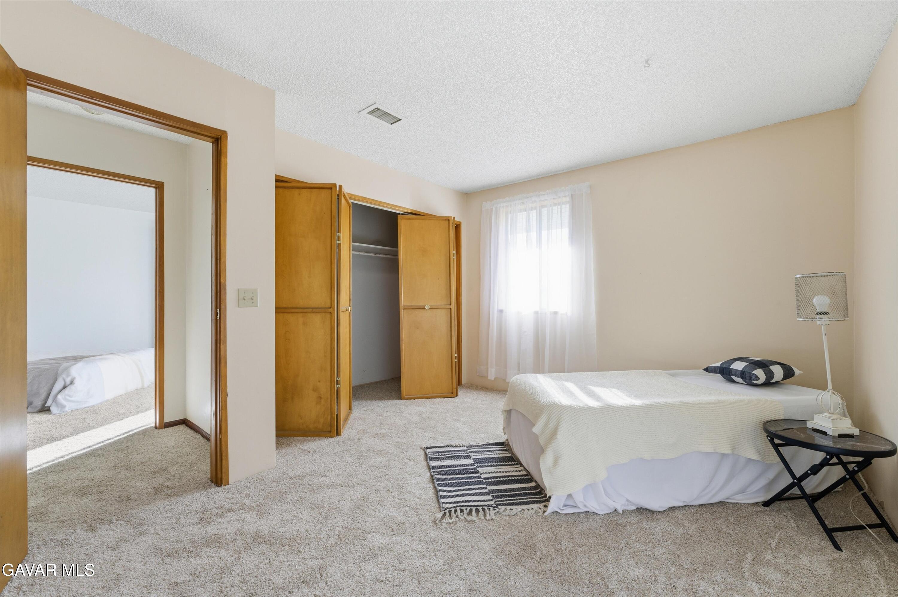 26181 Bear Valley Road Tehachapi, CA 93561 - Photo 20 of 38 a bedroom with a bed and wooden floor
