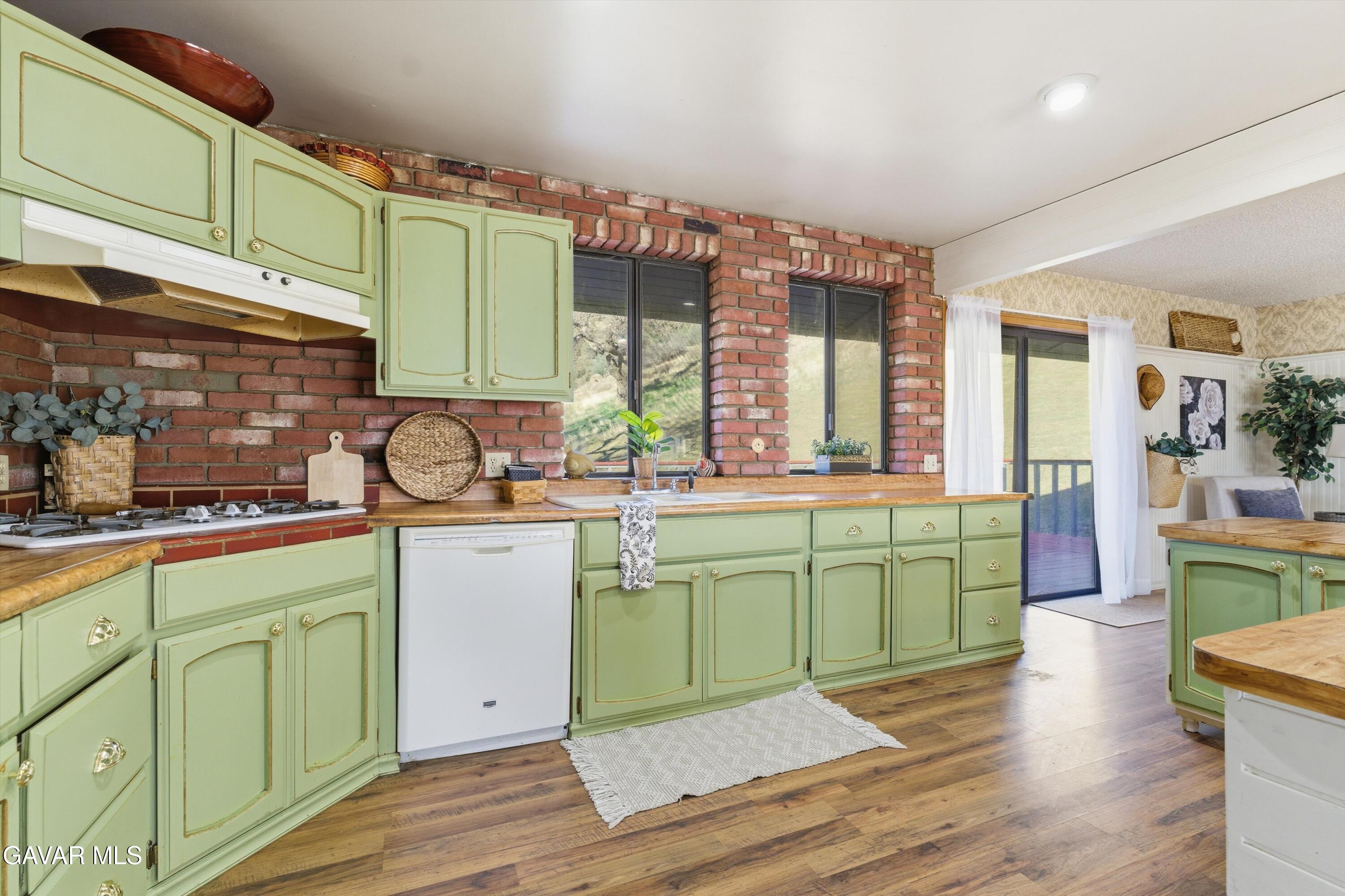 26181 Bear Valley Road Tehachapi, CA 93561 - Photo 23 of 38 a kitchen with sink and cabinets with wooden floor