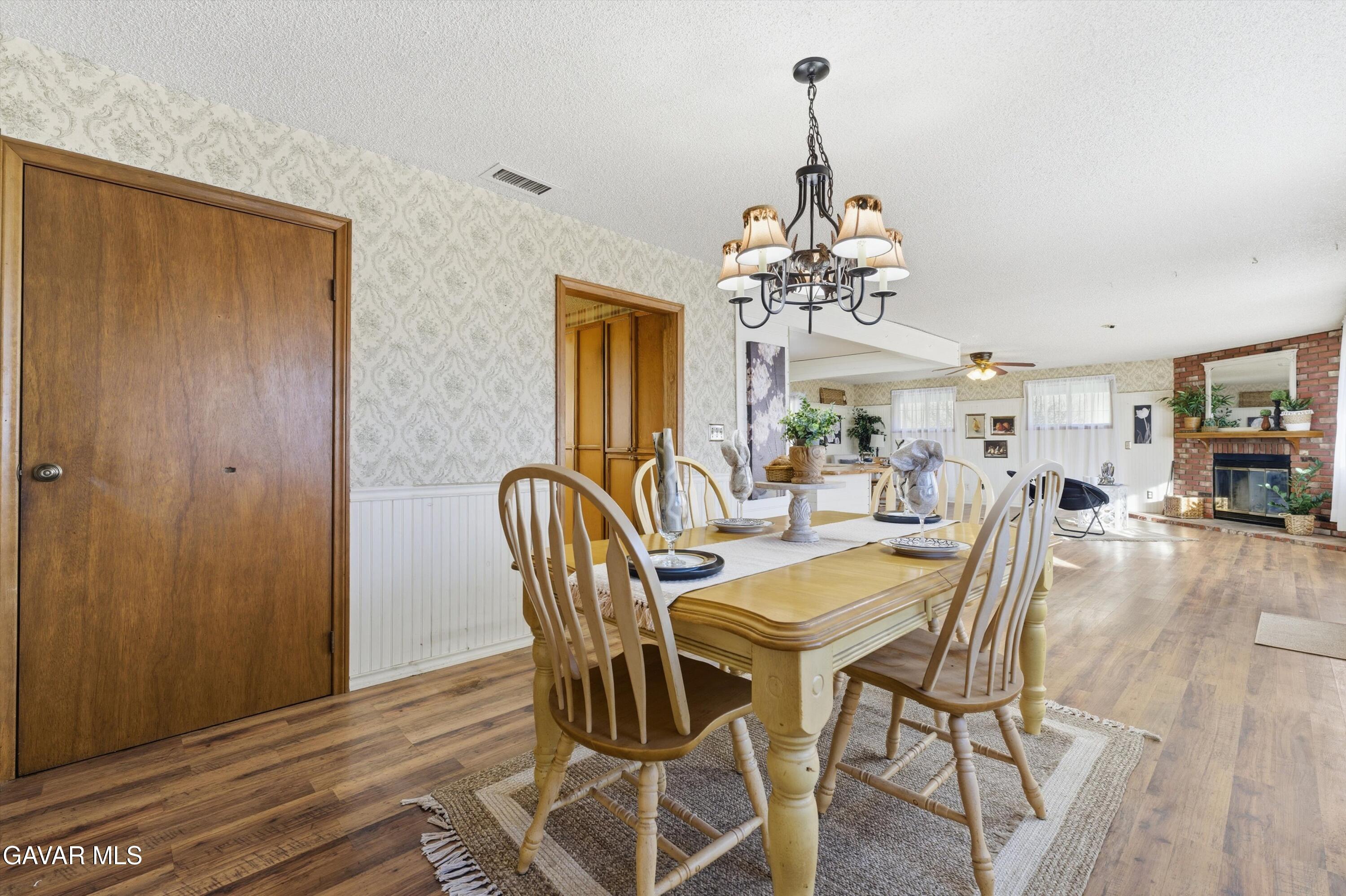 26181 Bear Valley Road Tehachapi, CA 93561 - Photo 25 of 38 a view of a dining room with furniture a chandelier and wooden floor