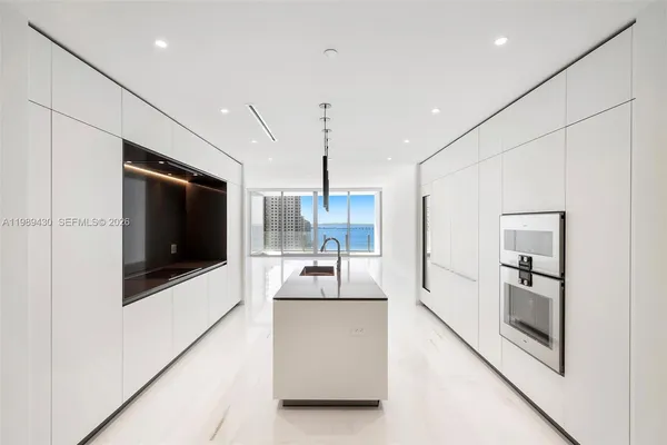 a kitchen with kitchen island stainless steel appliances a stove refrigerator sink and fireplace