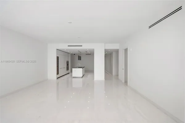 a view of an empty room with a kitchen