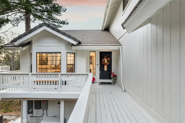 a view of wooden house with large windows and a table and chairs
