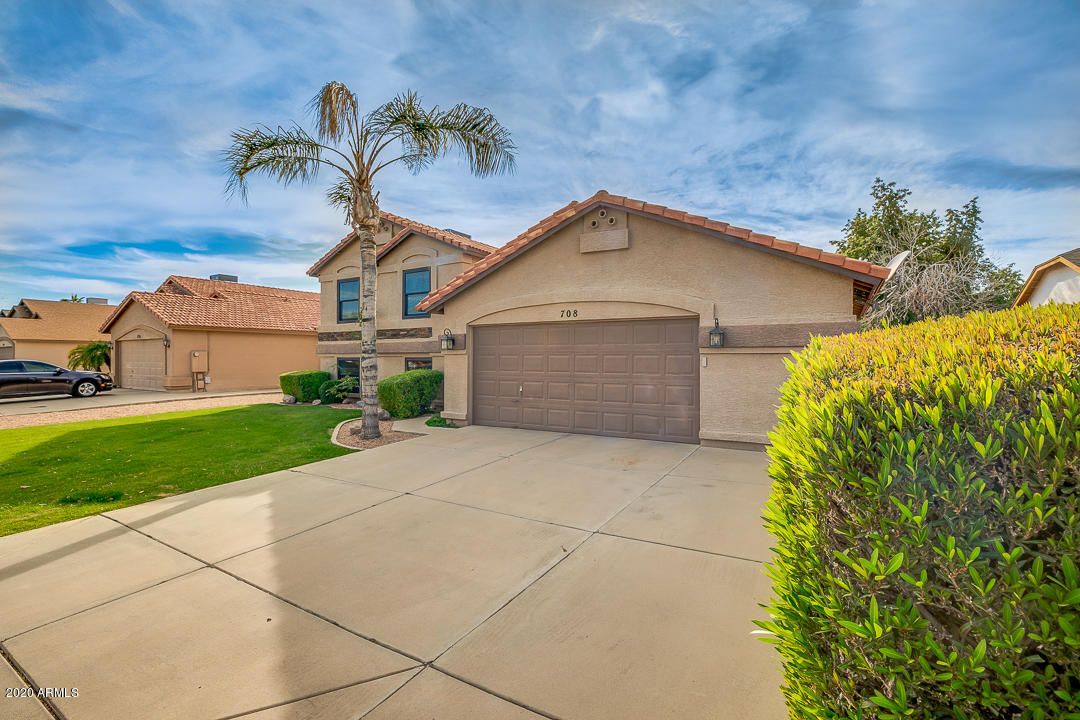 708 South Riata Street Gilbert, AZ 85296 - Photo 3 of 52 a front view of a house with a garden and yard