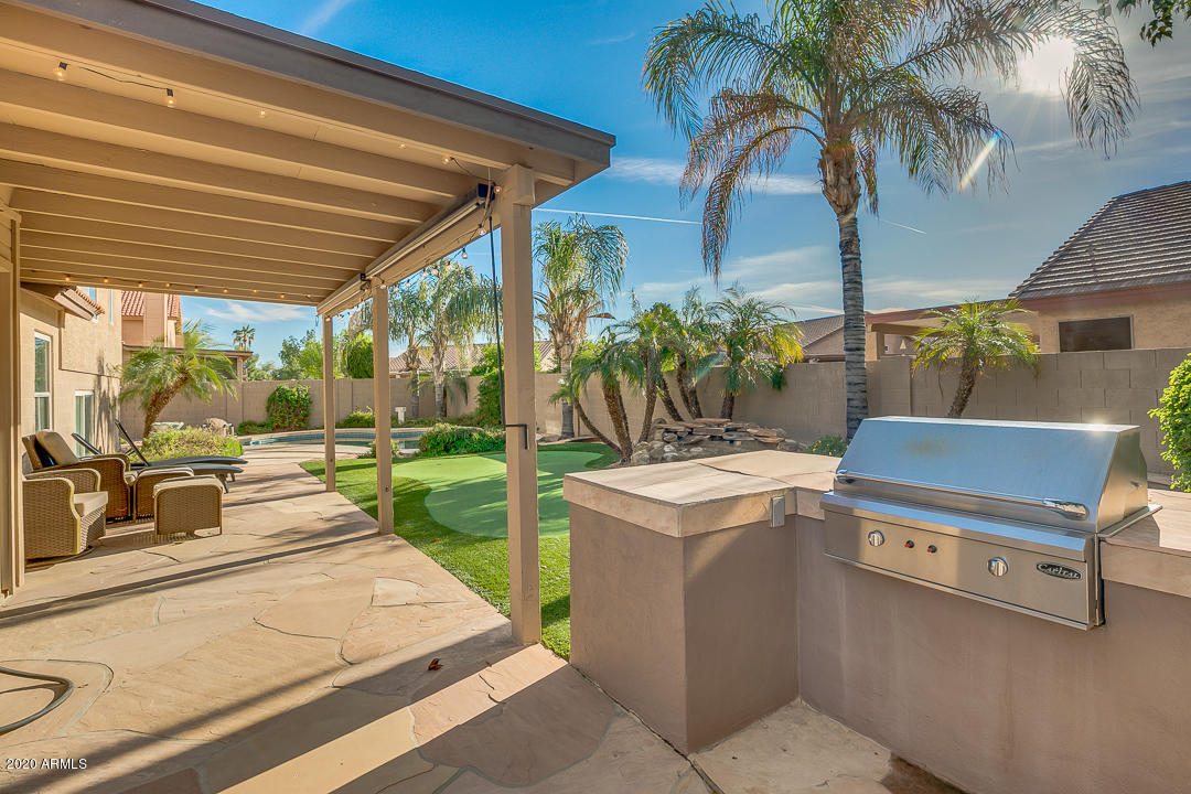 708 South Riata Street Gilbert, AZ 85296 - Photo 46 of 52 a view of a patio with a table and chairs under an umbrella