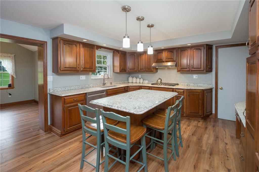 2387 Harrison City Road Export, PA 15632 - Photo 8 of 25 a kitchen with granite countertop kitchen island wooden floor center island and stainless steel appliances