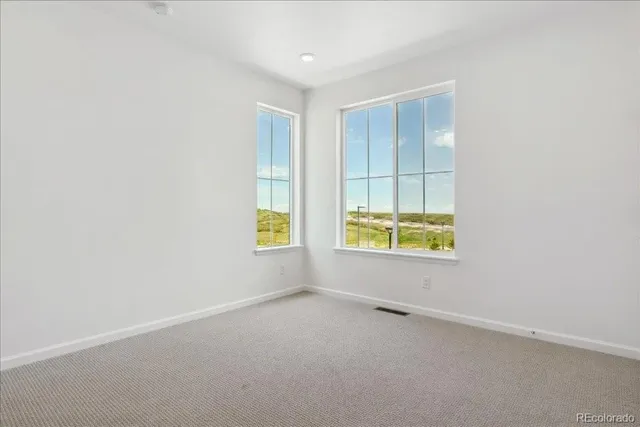 an empty room with windows and mirror