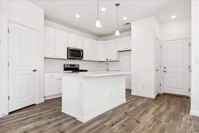 a kitchen with a refrigerator and a stove top oven