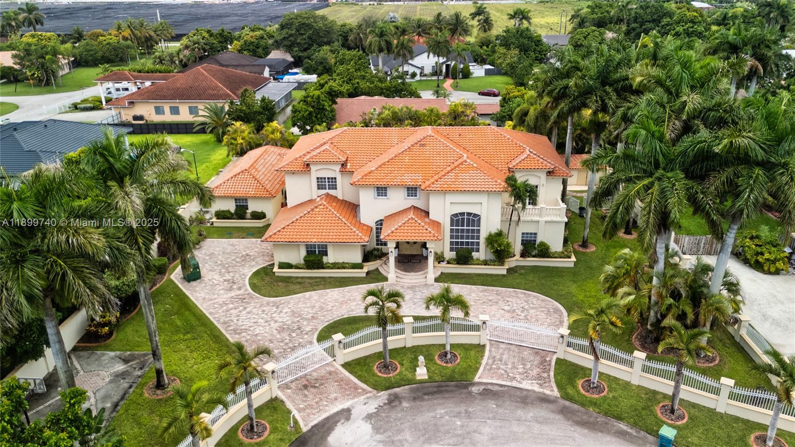 an aerial view of a house with swimming pool and red chairs
