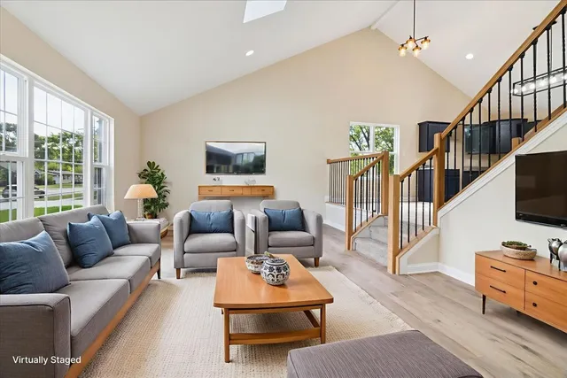 a living room with furniture flat screen tv and a window