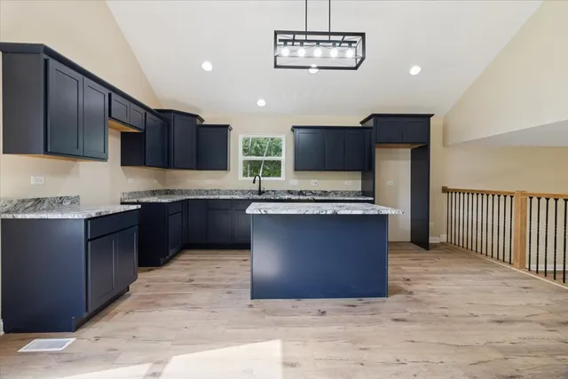 a large kitchen with stainless steel appliances granite countertop a stove a sink dishwasher and a microwave oven on the wooden floor