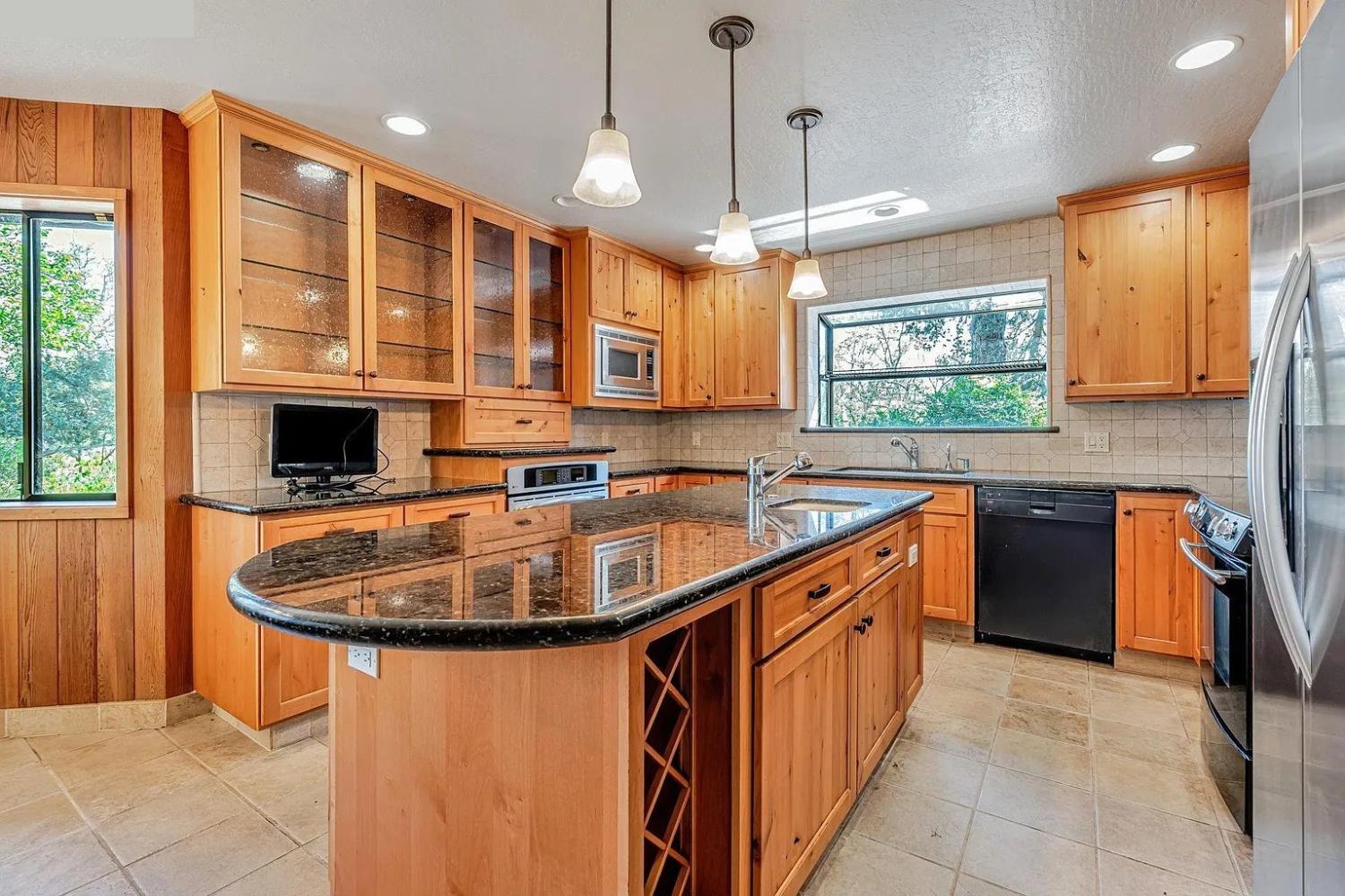 4607 Archerdale Road Linden, CA 95236 - Photo 13 of 50 a kitchen with stainless steel appliances granite countertop a sink and a stove
