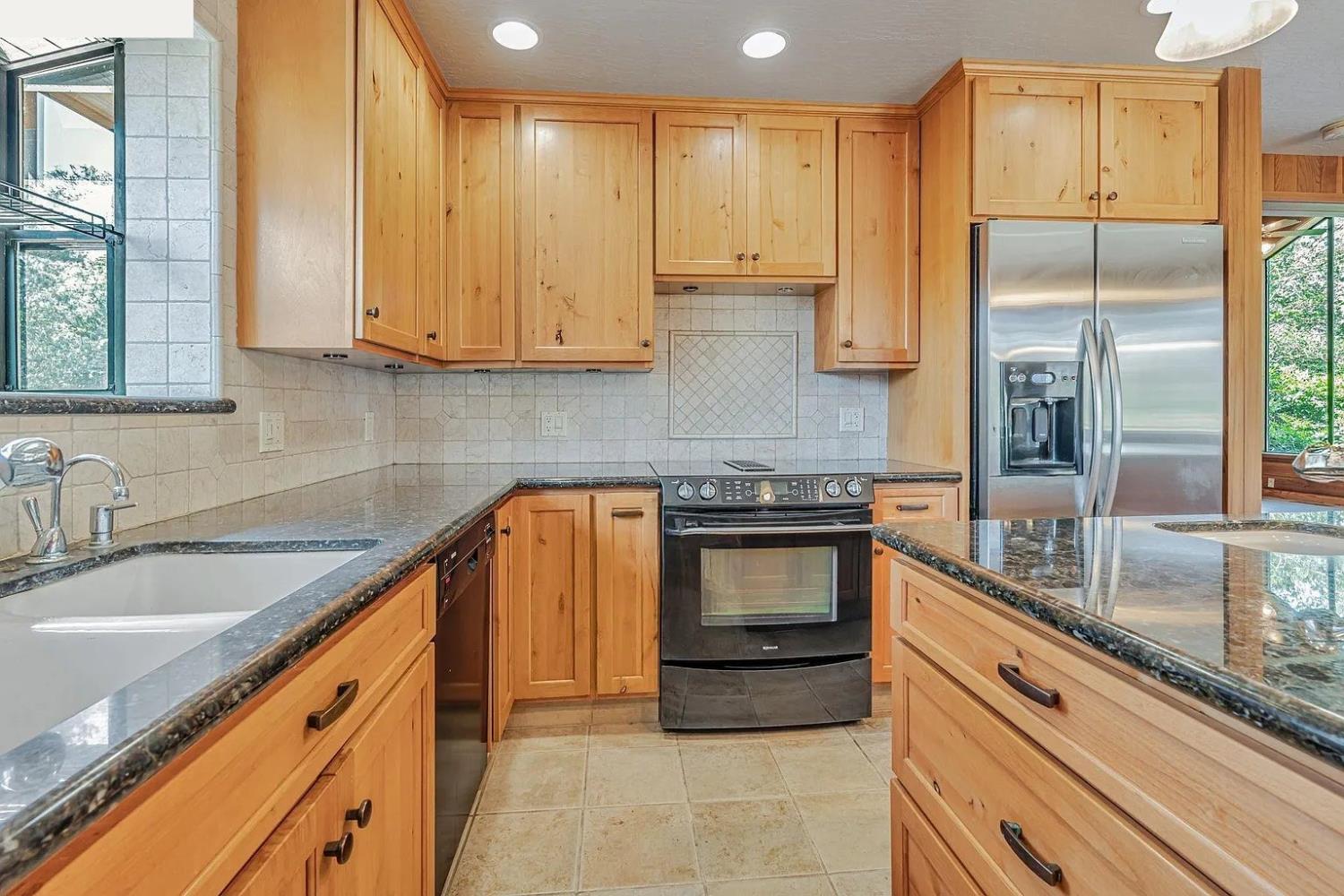 4607 Archerdale Road Linden, CA 95236 - Photo 15 of 50 a kitchen with stainless steel appliances granite countertop a sink a stove and a refrigerator