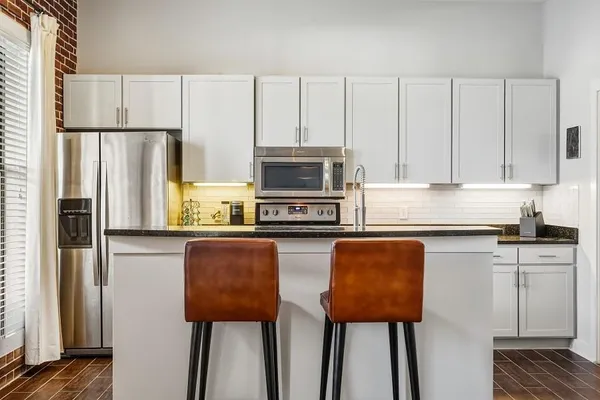a kitchen with stainless steel appliances granite countertop a refrigerator a stove top oven a sink and dishwasher