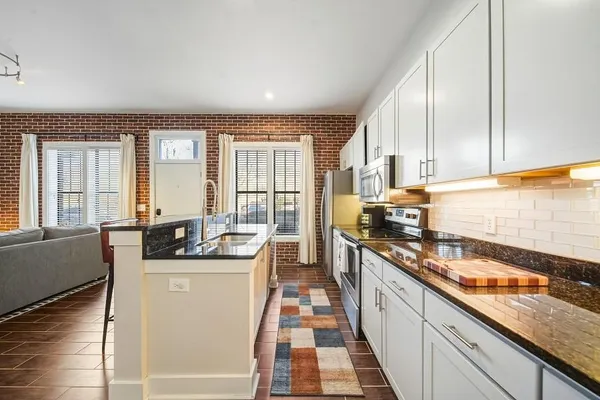 a kitchen with stainless steel appliances granite countertop a sink stove and cabinets