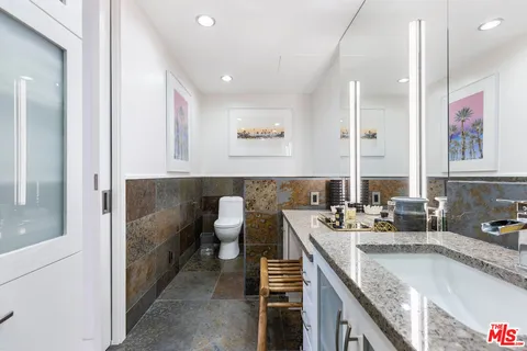 a bathroom with a granite countertop sink and a mirror