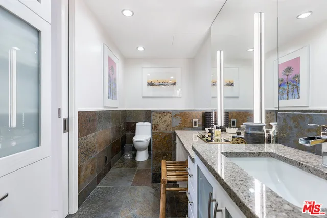 a bathroom with a granite countertop sink and a mirror