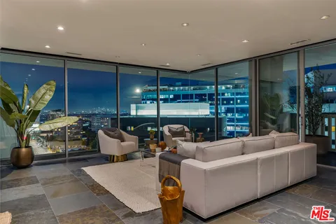 a living room with furniture a lamp and potted plant