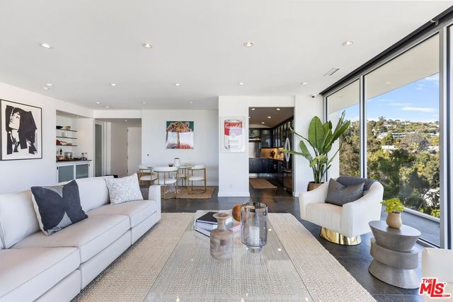 a living room with furniture and floor to ceiling windows