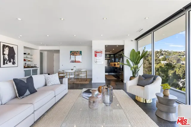 a living room with furniture and floor to ceiling windows