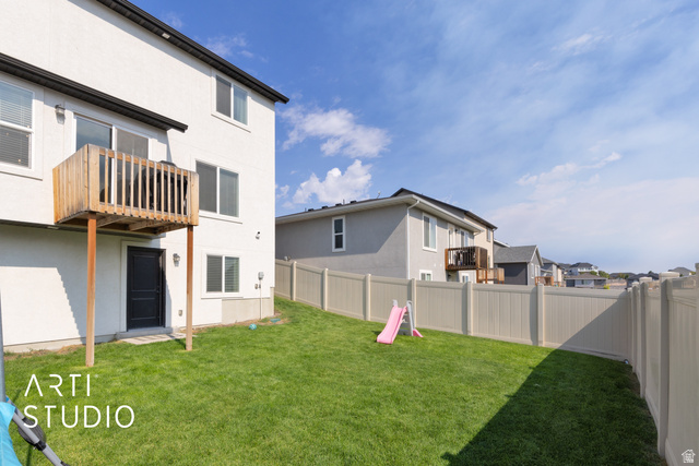 1713 South Windemere Road Santaquin, UT 84655 - Photo 26 of 40 Expansive backyard featuring a manicured lawn, full fencing, a ground-level exterior door, and an upper-level wood deck
