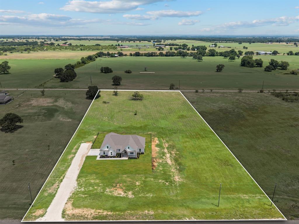 2705 Gospel Road Tolar, TX 76476 - Photo 2 of 36 Expansive property featuring a single-story residence with a light-colored exterior, a multi-gabled roofline, and a long gravel driveway