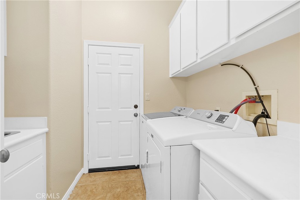 1195 Pamplona Drive Riverside, CA 92508 - Photo 28 of 39 The laundry room has a sink and plenty of storage. The door leads to the 2 car garage.