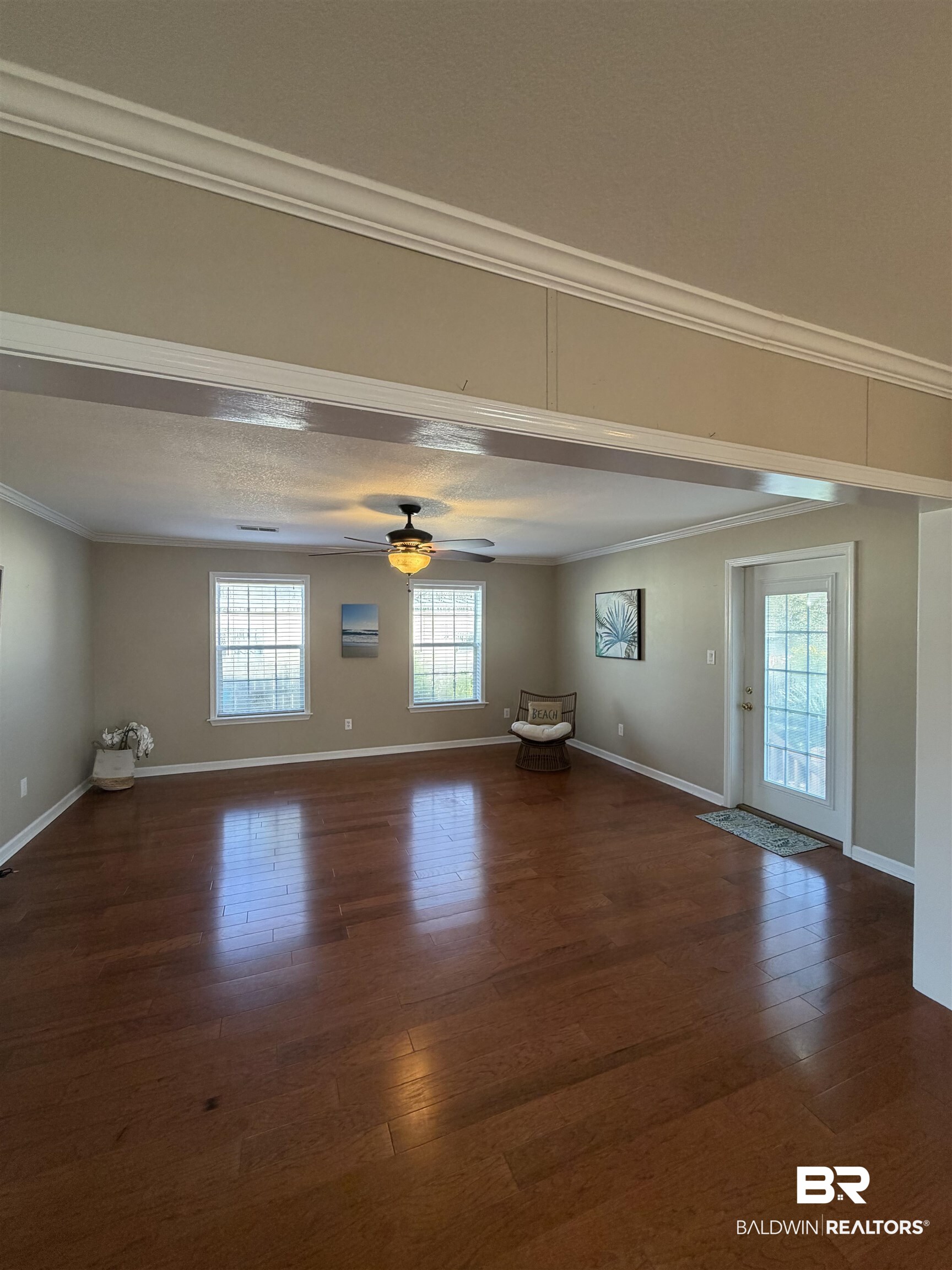675 Escambia Loop Lillian, AL 36549 - Photo 15 of 44 Unfurnished room featuring ceiling fan, ornamental molding, and dark wood-style flooring