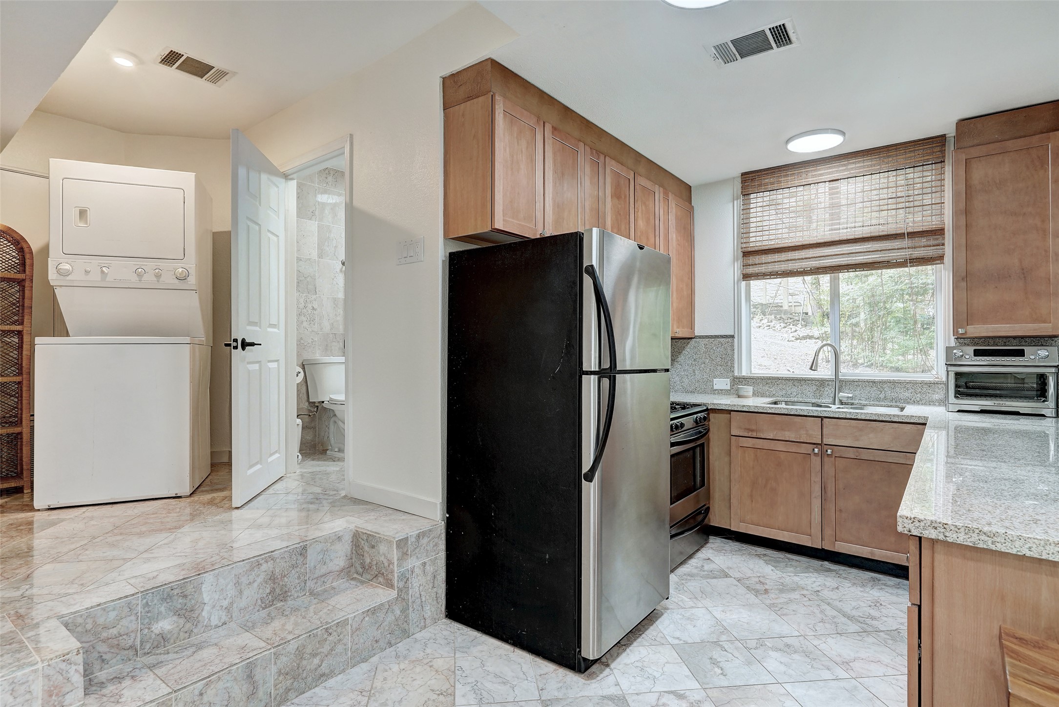 8804 Mountain Ridge Drive, Unit B Austin, TX 78759 - Photo 10 of 17 A compact kitchen with sleek appliances and practical tile flooring.