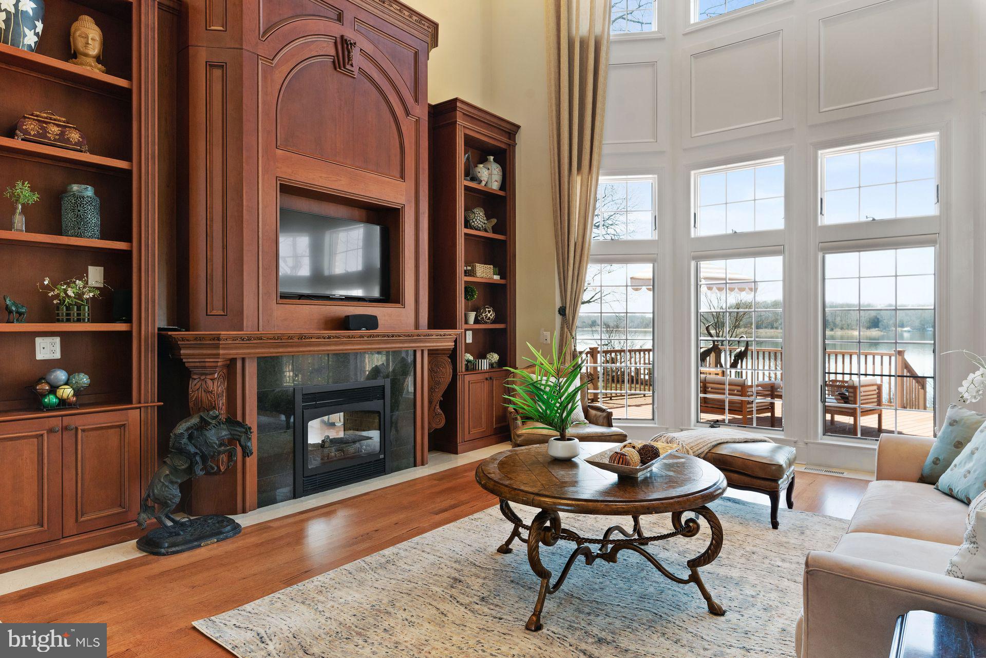 4132 Cadle Creek Road Edgewater, MD 21037 - Photo 13 of 85 a living room with furniture a fireplace and floor to ceiling windows