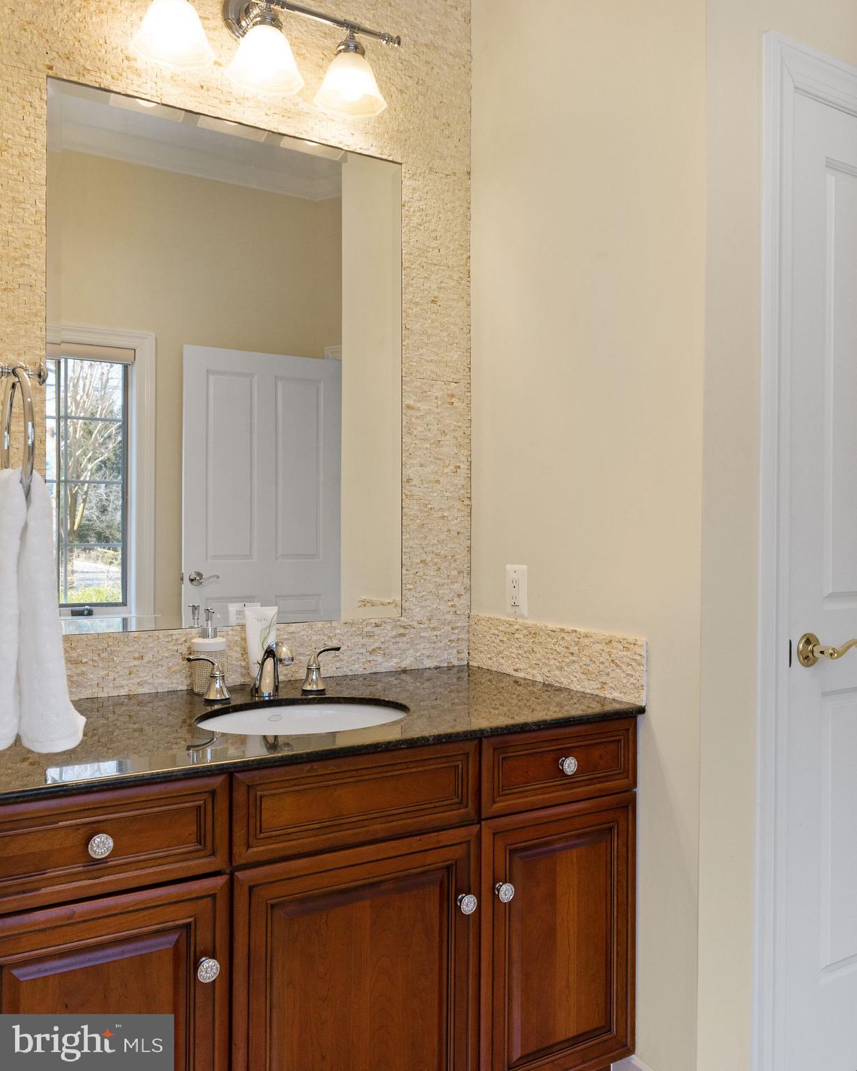 4132 Cadle Creek Road Edgewater, MD 21037 - Photo 35 of 85 a bathroom with a granite countertop sink and a mirror