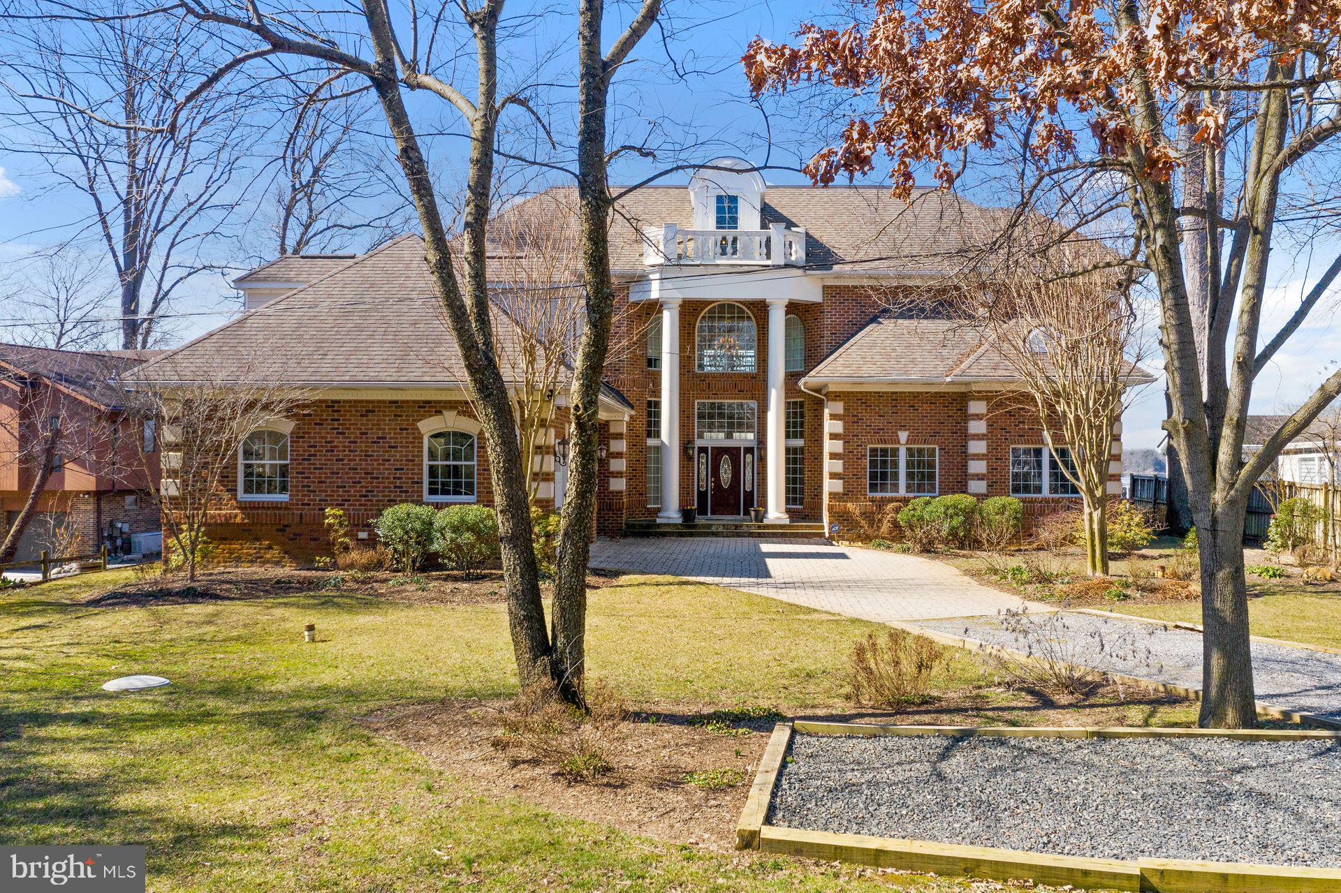 4132 Cadle Creek Road Edgewater, MD 21037 - Photo 64 of 85 a view of a brick house with large windows and a tree