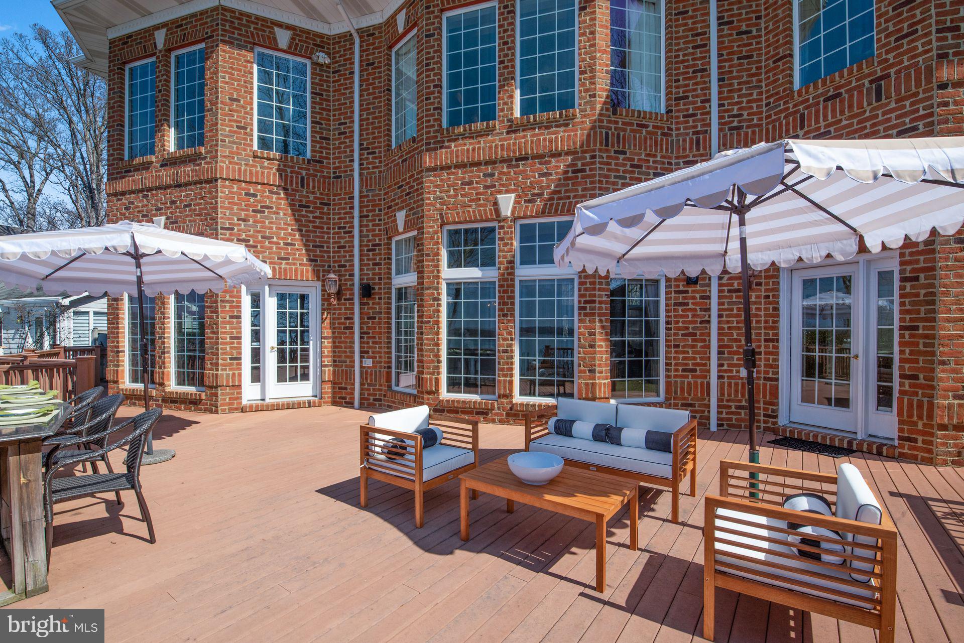 4132 Cadle Creek Road Edgewater, MD 21037 - Photo 71 of 85 a patio with a table and chairs under an umbrella