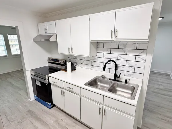a view of kitchen with sink a stove and refrigerator