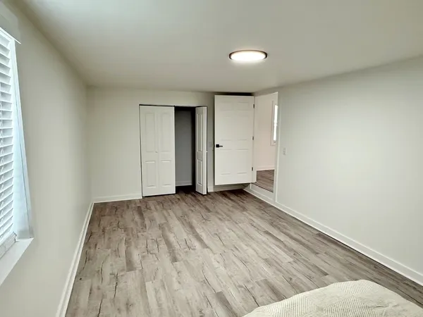 a view of a hallway with wooden floor and staircase
