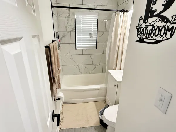 a bathroom with a sink and bathtub with toilet
