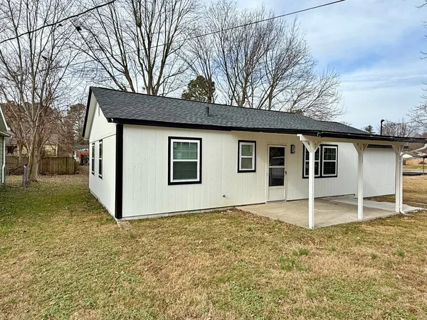 a house that has a large tree in front of it