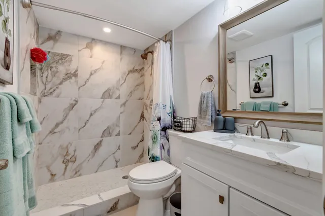 a bathroom with a sink toilet and shower