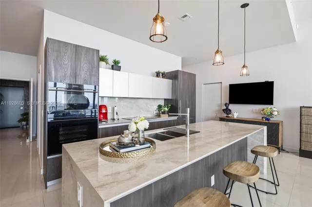 a kitchen with stainless steel appliances kitchen island granite countertop a sink a stove and a refrigerator