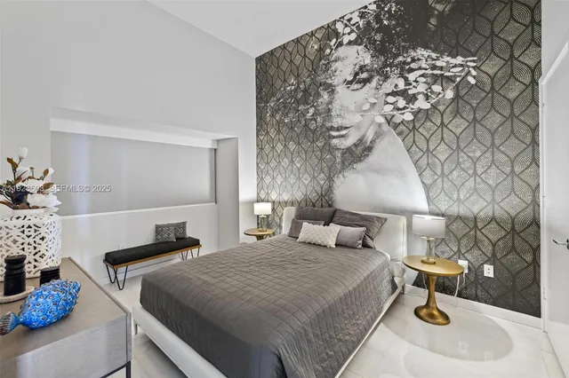 a bedroom with a bed and a lamp on the dresser