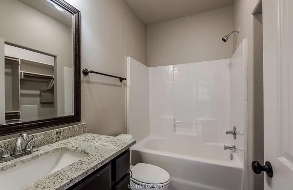 a bathroom with a granite countertop sink toilet and shower